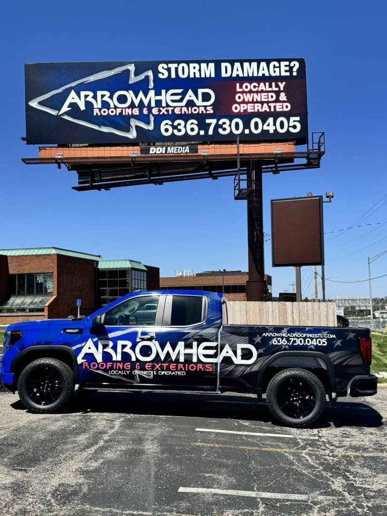 Arrowhead Roofing & Exteriors truck and billboard with contact info, serving Greater St. Louis homeowners, parked outdoors.