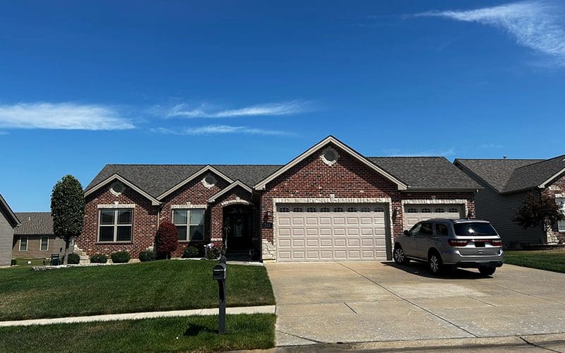 St. Louis single-story brick home with two-car garage and manicured lawn—ideal for roofing, siding, or gutter upgrades.